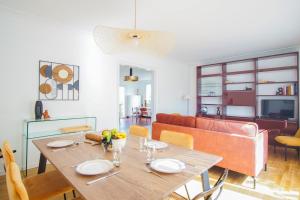 a dining room and living room with a wooden table at -ERNEST-Maison avec jardin a 200m des plages in Concarneau