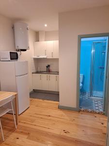 una cucina con armadi bianchi e una porta blu di Near River 63 a Vila Nova de Gaia