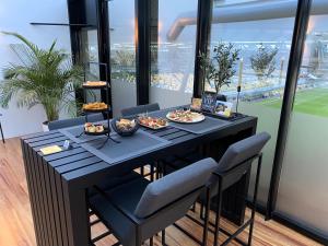einen Tisch mit Essen in einem Zimmer mit Fenstern in der Unterkunft Wellness Dome Penthouse in Kerkrade