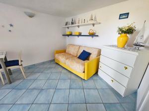 a living room with a yellow couch and a dresser at Maridea - Sottovento in Ponza