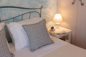 a bed with two pillows and a table with a lamp at 9 Muses Naxos Beach hotel in Kastraki