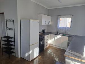 a kitchen with a white refrigerator and a stove at 22 Duvenhage in Postmasburg