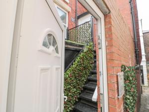 ウィットビーにあるEllerby Lane Houseの階段のあるレンガ造りの建物へのドア