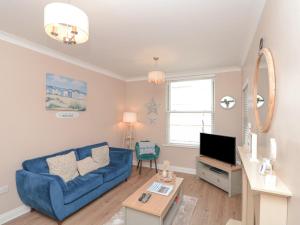 ウィットビーにあるEllerby Lane Houseの青いソファとテレビのあるリビングルーム