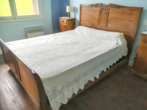 a bedroom with a large bed with a wooden headboard at Maison de 3 chambres avec jardin clos a Lacam d'Ourcet in Lacam-dʼOurcet