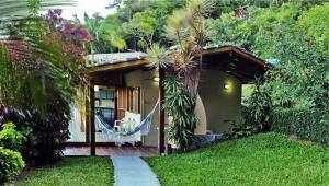 a house with a hammock in front of it at Condomínio Aldeia dos Anjosdo Rosa in Praia do Rosa