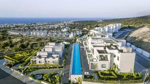 une vue aérienne d'un complexe hôtelier près de l'océan dans l'établissement Premium HOME: Bungalow-Apartment mit Rooftop nahe Golfclub & SPA, à Ayios Yeoryios