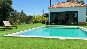a swimming pool in a yard next to a house at Monte da Marouca-Mont’Argil in Montargil