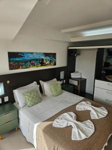 a bedroom with a large bed with white sheets at Flat with sea view Pipa's Bay in Pipa +27 photos