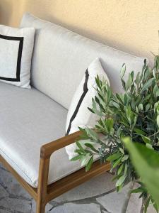 a white couch with a pillow and a plant at Hôtel Gallia Cannes in Cannes