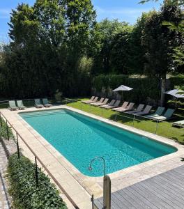 una piscina con sillas y sombrillas en un patio en Hôtel & Restaurant - L'Écu de Bretagne, en Beaugency