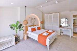 a bedroom with a large bed with an orange blanket at Hotel Pastel Kaş in Kas