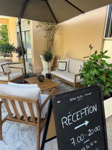 a patio with chairs and a sign for a reception at Hôtel Gallia Cannes in Cannes