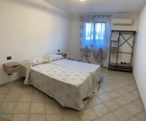 a bedroom with a large bed and a window at Fema House Solità in Budoni