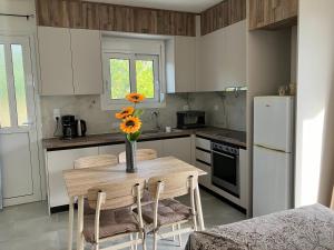 a kitchen with a wooden table with a vase of flowers on it at Kamena Home Apartment in Kamena Vourla in Kamena Vourla