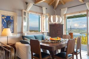 a dining room with a table with a bowl of fruit on it at Lefkada Collection Villas in Lygia +48 photos