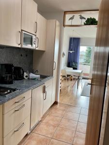 een keuken met witte kasten en een woonkamer bij Berliner Ring - Whg 27 in Wyk auf Föhr