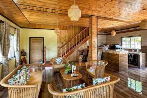 a living room with wicker chairs and a wooden ceiling at La Villa Hortensia 3 - 8 personnes in La Digue