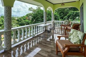 a porch with chairs and a table on a balcony at La Villa Hortensia 3 - 8 personnes in La Digue