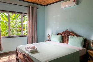 a bedroom with a large bed with a window at La Villa Hortensia 3 - 8 personnes in La Digue