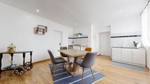 a kitchen and dining room with a wooden table and chairs at Cosy et Chic Centre Ville in Tulle