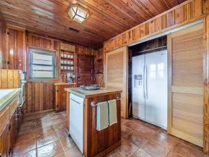 a kitchen with wooden walls and a white refrigerator at Sea Strapped in Surf City