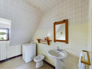 Un baño con lavabo, inodoro y espejo. en -BAYA- Authentique & familiale a l Anse de Rospico, en Névez 19 fotos más