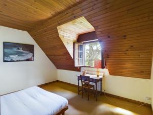 Un dormitorio con una cama y una mesa y una ventana. en -BAYA- Authentique & familiale a l Anse de Rospico, en Névez