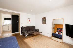 a living room with a couch and a mirror at Stylish Fitzrovia Studios W1 in London