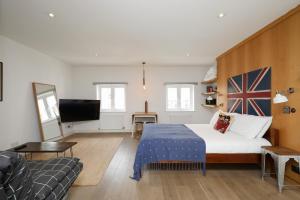 a bedroom with a bed and a couch and a television at Stylish Fitzrovia Studios W1 in London