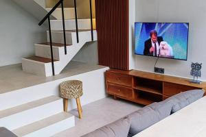 a living room with a flat screen tv on a wall at Alodia Villa with pool & kitchen in Sanur