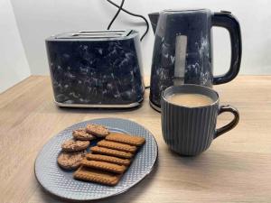 a table with a plate of cookies and a cup of coffee at LeeVal Detached House parking in Stockton-on-Tees +16 photos