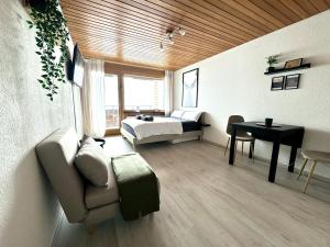 莱克斯Studio mit See- und Bergblick的一间卧室配有一张床、一张桌子和一张沙发