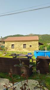a picnic table and chairs in front of a building at El nido del cuco in Padrón