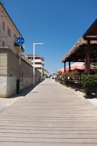 ein leerer Bürgersteig mit einem Gebäude und einem blauen Schild in der Unterkunft Appartamento sul mare in Francavilla al Mare