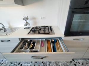 eine Küche mit einem Herd und einer Schublade mit Küchenutensilien in der Unterkunft Appartamento sul mare in Francavilla al Mare + 15 Fotos