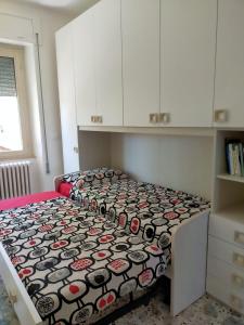 ein Schlafzimmer mit einem Bett mit einer Bettdecke darauf in der Unterkunft Appartamento sul mare in Francavilla al Mare