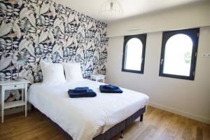 a bedroom with a bed with two blue towels on it at -TY AR MOR- Belle maison corniche a 150m de la mer in Concarneau