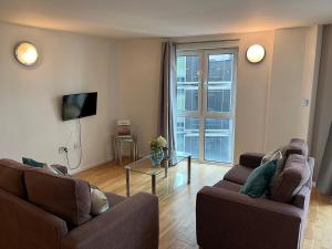 a living room with two couches and a television at Access Apartments City in London