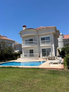 a large house with a swimming pool in front of it at Belek Golf Village - Villa with private pool in Belek