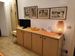 una scrivania con una televisione e una lampada di Appartamento Basuetta alle Cinque Terre con AC a Monterosso al Mare