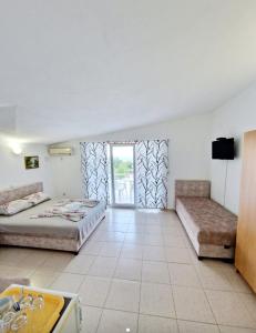 a large room with two beds and a window at Apartmani ARIANA in Dobra Voda