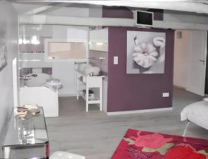 ein Wohnzimmer mit einer lila Wand mit einer Blume darauf in der Unterkunft Appartement d'une chambre avec terrasse amenagee et wifi a Saint Genes du Retz in Saint-Genès-du-Retz