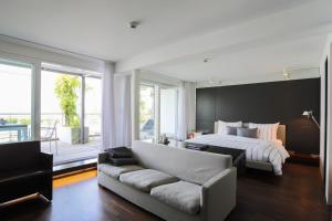 1 dormitorio con cama blanca y sofá en Marina Lachen, en Lachen