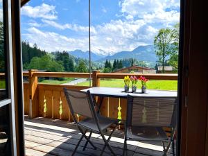 a table and chairs on a balcony with a view of a mountain at Alpenlodge Charivari - SommerBergBahn unlimited kostenlos in Oberstdorf