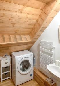 eine Waschküche mit einer Waschmaschine und einem Waschbecken in der Unterkunft Maison de 2 chambres avec jardin amenage et wifi a Chaumeil in Chaumeil