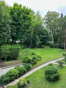 a garden with bushes and trees and a walkway at Chambre indépendante dans résidence calme, proche Paris in Bougival