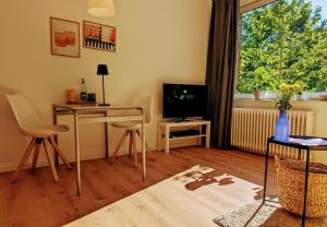 a living room with a desk and a television at Apartment mit Balkon in Hannover-Ahlem in Hannover