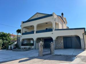 a large white house with a garage at Apartman Meld in Vrh