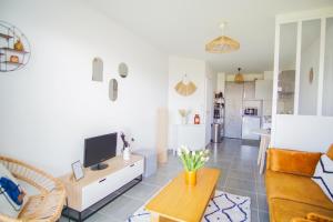 un salon avec un canapé et une télévision dans l'établissement -YSA- VUE MER - parc de la thalasso avec piscine, à Concarneau